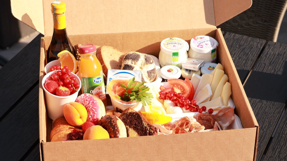 Frühstücksbox mit frischem Obst, Käse, Aufschnitt und Gebäck
